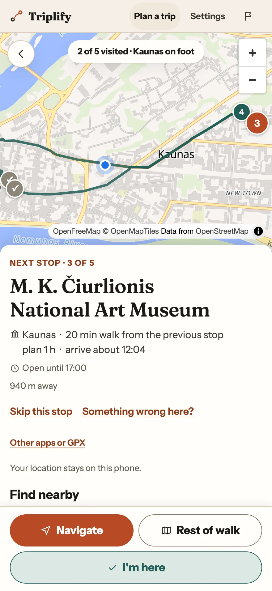 Phone walking companion with 2 of 5 stops visited, a map showing your position, and the next stop: M. K. Čiurlionis National Art Museum, arriving about 12:04.